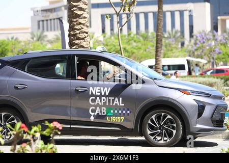 Nuova capitale amministrativa, Egitto. 15 maggio 2024. Le persone sperimentano un taxi elettrico durante una cerimonia pilota nella nuova capitale amministrativa, in Egitto, il 15 maggio 2024. L'Egitto ha avviato il programma pilota mercoledì per gestire la prima flotta di taxi elettrici del paese nella nuova capitale amministrativa (NAC), con l'obiettivo di fornire opzioni di trasporto ecologiche e intelligenti. Crediti: Ahmed Gomaa/Xinhua/Alamy Live News Foto Stock