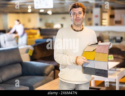 Uomo di mezza età mostra tessuto di tappezzeria Foto Stock