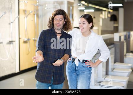 Donna e uomo che discutono della lista di shopping e che indicano qualcosa nel deposito Foto Stock