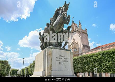 7 agosto 2023 - Gravina in Puglia, Italia - la villa comunale della città con il monumento alla guerra. Le aiuole di fiori e il prato del guardaroba ben tenuto Foto Stock