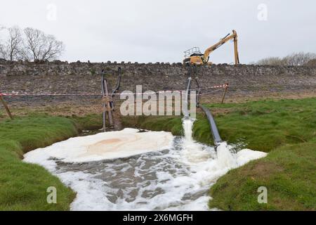 Canale di drenaggio nella palude salata di Grange sopra Sands, Cumbria, Regno Unito, l'acqua viene pompata via dopo un deragliamento il 22/3/24 Foto Stock