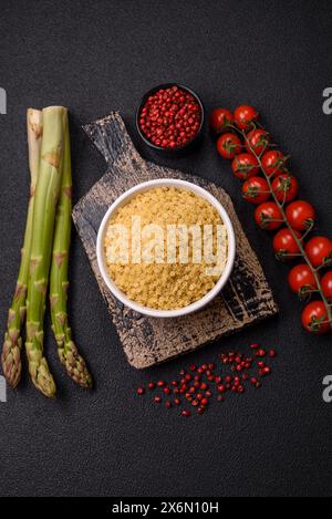 Pasta stellina cruda di grano duro con sale e spezie su fondo di cemento scuro Foto Stock