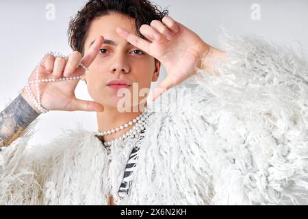 Giovane bruna ispanica gay uomo con trucco naturale che guarda telecamera isolata su sfondo bianco ritratti in studio persone lgbt stile di vita e moda Foto Stock