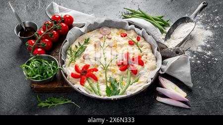 Focaccia cruda su sfondo scuro. Cucina italiana. Vista dall'alto, banner Foto Stock