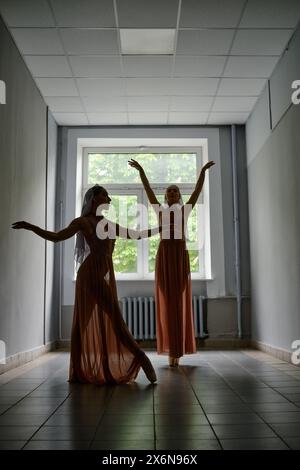 Silhouette di due ballerine che provano coreografie nel corridoio del teatro Foto Stock