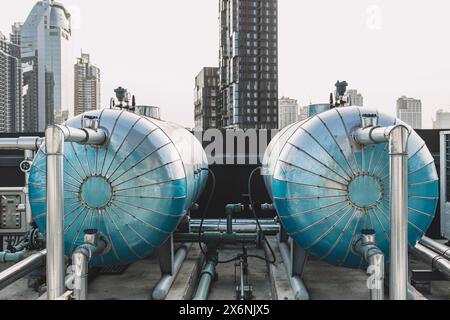 Grande serbatoio a pressione isolato in acciaio inox per l'acqua calda per l'hotel sul tetto esterno con sistema a pompa di calore con tubo dell'acqua calda. Foto Stock