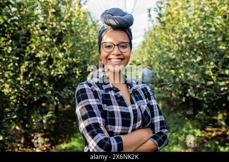 Ritratto di una giovane agricoltrice afroamericana in un frutteto. Foto Stock
