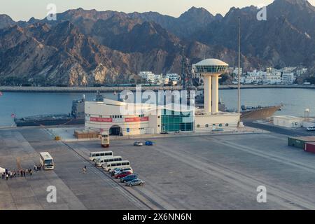 Mascate, Oman - 2 gennaio 2024: Il porto prende vita con il caldo bagliore del tramonto, mettendo in risalto la danza quotidiana del commercio e della natura. Foto Stock
