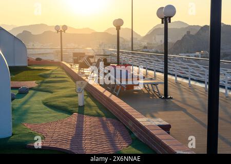 Mascate, Oman - 2 gennaio 2024: Una tranquilla mattinata sul ponte di una nave da crociera di lusso, con i passeggeri che si godono la vista mozzafiato della bocca di Mascate Foto Stock