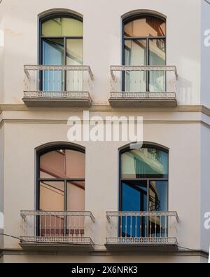 Dettaglio di un edificio residenziale con finestre colorate e balconi bianchi a Malaga, Andalusia, Spagna meridionale. Foto Stock