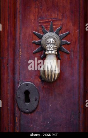 Una grande porta in ottone bussa a forma di mano su una vecchia porta in legno a Malaga, Andalusia, Spagna meridionale. Foto Stock