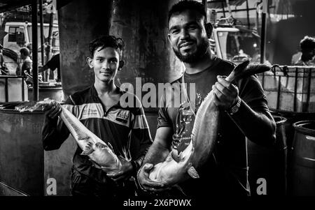 A Jatrabari, Dacca, Bangladesh, i venditori si affollano di attività, vendendo pesce nel vivace mercato del pesce all'ingrosso la mattina presto. Questa immagine era maiuscola Foto Stock