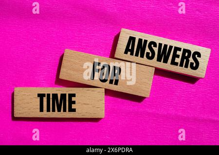Tempo per le risposte parole scritte su blocchi di legno con sfondo rosa. Simbolo tempo concettuale per le risposte. Copia spazio. Foto Stock
