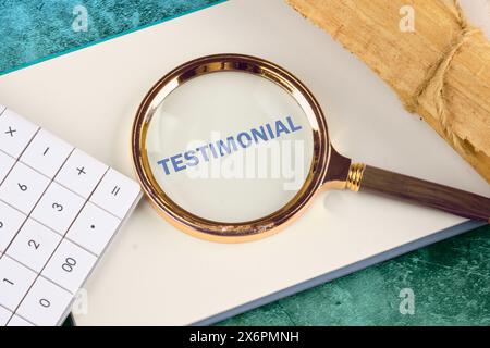 TESTIMONIANZA scritta attraverso una lente d'ingrandimento su un foglio bianco di blocco note accanto a una calcolatrice e un rotolo di papiro Foto Stock