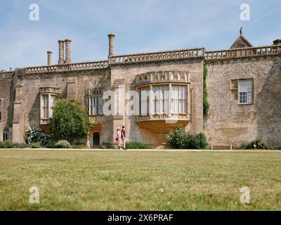 I visitatori estivi passeggiano per l'abbazia di Lacock in estate, Wiltshire, Inghilterra, Regno Unito Foto Stock