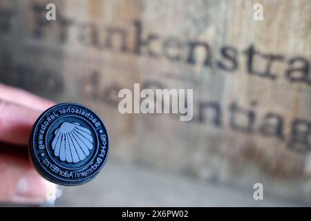 Adorf, Germania. 16 maggio 2024. L'agricoltore biologico Bert Bochmann tiene in mano un francobollo da pellegrino proveniente dalla via sassone di San Giacomo. La fattoria si trova su un sentiero medievale che collega il monastero di Chemnitz, che ora fa parte della via sassone di San Giacomo. L'offerta per gli escursionisti in cerca di illuminazione deve essere ampliata. Tra un anno, le abitazioni portatili per i pellegrini potrebbero trovarsi nei prati di Erzgebirge tra mucche e cavalli. Crediti: Jan Woitas/dpa/Alamy Live News Foto Stock