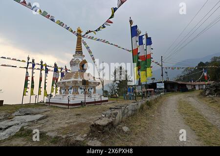 Kutumsang, Nepal - 17 aprile 2024: Un corten buddista tibetano o stupa e bandiere di preghiere, nel villaggio Tamang lungo l'Helambu Trek Foto Stock