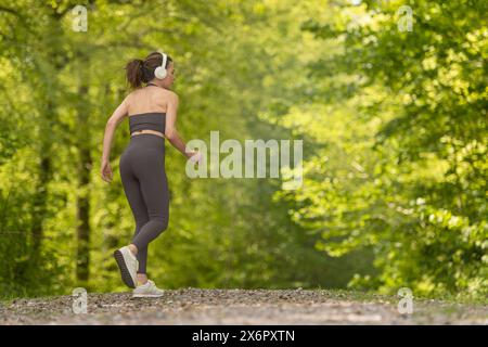 donna sportiva che corre in campagna su un sentiero. concetto di fitness all'aperto Foto Stock