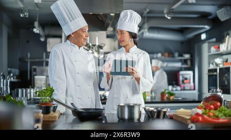 Ritratto di Black Female Chef prende le erbe fresche, ama l'odore con un sorriso, ingrediente segreto che rende speciale la ricetta della nonna. Cucina tradizionale del ristorante con piatti autentici, cibo salutare Foto Stock