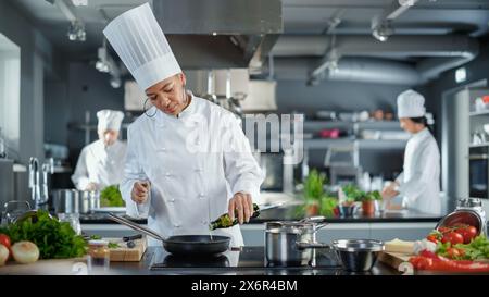 Cucina del ristorante: Chef donna nera che cucina piatti deliziosi e tradizionali, utilizza olio in padella preparandosi a friggere biologiche con carne a scelta libera. Preparazione di piatti gourmet. Grandangolo Foto Stock