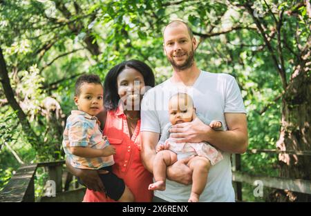 famiglia con due bambini nella foresta che si divertono molto Foto Stock