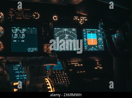 Vista in cabina di pilotaggio di un velivolo durante un volo notturno con quadri strumenti illuminati Foto Stock