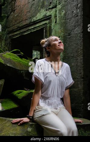 Donna turistica caucasica che contempla la grandezza delle rovine di Angkor Wat nel Tempio di Ta Prohm Foto Stock