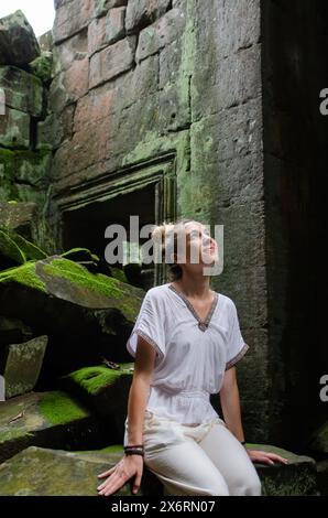 Donna turistica caucasica che contempla la grandezza delle rovine di Angkor Wat nel Tempio di Ta Prohm Foto Stock