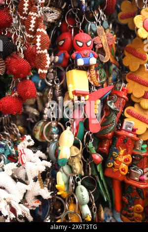 Immagine completa astratta di souvenir, mercato municipale di Antigua, Guatemala. Recuerdos, tieni il sorte, borse, bigiotteria colorata in una banchina del mercato. Niente persone. Foto Stock