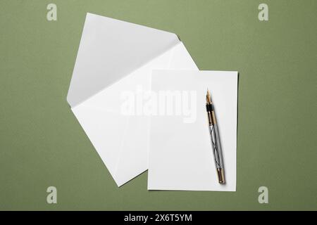 Foglio di carta vuoto, busta Letter e penna su sfondo verde, vista dall'alto Foto Stock