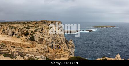 Espectacular paisaje desde el Faro del Cabo de Cavalleria. Junto a los acantilados, una familia disfrutando de las Vistas. Minorca, España Foto Stock