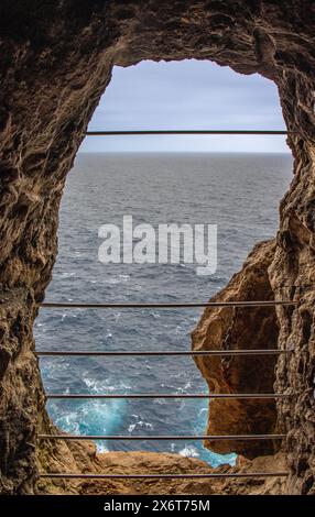 Al final de la cueva próxima al faro de Cavalleria se puede disfrutar del paisaje de mar y acantilados. Minorca España Foto Stock