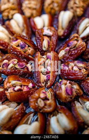 Datteri ripieni gourmet con pistacchi e mandorle da vicino, vista ravvicinata di datteri gourmet ripieni di mandorle e pistacchi, disposti splendidamente. Foto Stock