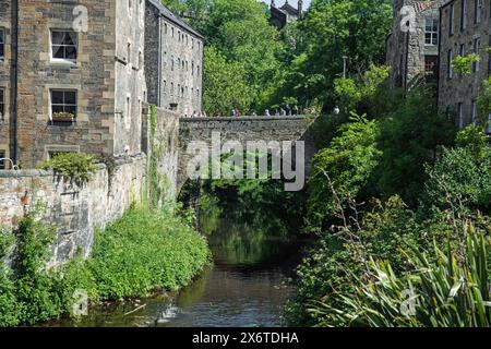 Turisti sul ponte Bells Brae sull'acqua di Leith a Dean Village, Edimburgo, Scozia, Regno Unito Foto Stock