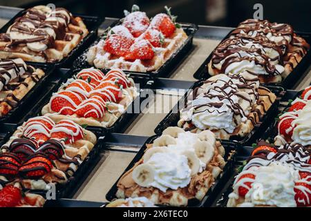 Waffle belgi tradizionali con diversi condimenti Foto Stock