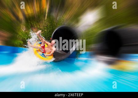 Sfocatura radiale dell'acqua di un uomo che scivola nel parco acquatico acqua Plus. Creta, Grecia. Foto Stock