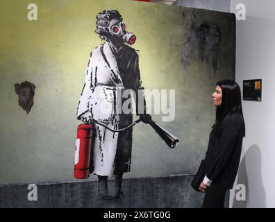 New York, New York, Stati Uniti. 15 maggio 2024. Donna con maschera di gas ed estintore', novembre 2022 sul muro di un edificio distrutto nella città di Gostomel, Ucraina, nel mezzo dell'invasione russa, visto all'apertura del nuovo Museo Banksy situato al 277 di Canal Street a Lower Manhattan. Oltre 160 opere d'arte Banksy sono state ricreate da 10 artisti anonimi, poiché tutti i pezzi tranne uno non esistono più. (Credit Image: © Nancy Kaszerman/ZUMA Press Wire) SOLO PER USO EDITORIALE! Non per USO commerciale! Foto Stock