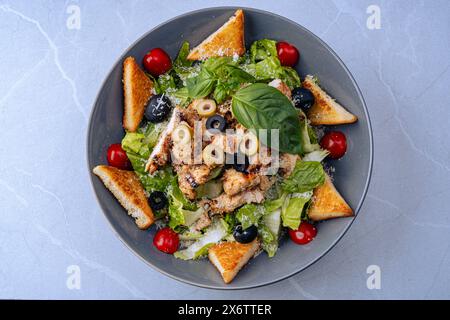Deliziosa Caesar Salad con pollo alla griglia, olive e pomodori ciliegini Foto Stock