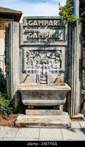 Brunate, Como, Lombardia, Italia. La Fontana di Campari è un'opera, parte di una serie di circa trenta fontane progettate da Giuseppe Gronchi, scultore fiorentino, per pubblicizzare l'azienda Davide Campari. Lo stile Deco è uno dei tre rimasti in Italia, mentre gli altri due si trovano a le piastre (provincia di Pistoia) e chiusi della Verna (provincia di Arezzo). Il corpo principale della fontana ha un bassorilievo con elementi grotteschi dai quali scorrono tre fontane. Foto Stock