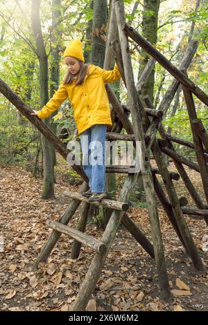 Parcheggio per bambini nel parco. Percorso ad ostacoli per bambini nel parco autunnale. La ragazza adolescente cammina con attenzione sui tronchi Foto Stock