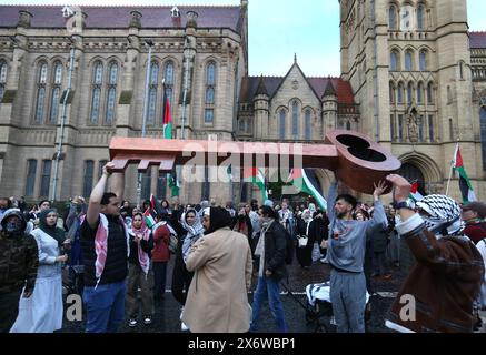 Manchester, Greater Manchester, Regno Unito. 15 maggio 2024. I manifestanti arrivano con le loro bandiere e striscioni all'Università di Manchester, alcuni portavano una chiave enorme dicendo "˜torneremo" attraverso la città. I manifestanti si recano per le strade di Manchester per commemorare il 76° anniversario della Nakba (la catastrofe), quando nel 1948 oltre 700.000 palestinesi sono fuggiti o sono stati espulsi dalle loro case e terre dai paramilitari e dallo Stato israeliano. Quella popolazione e i loro decenti hanno vissuto in esilio e promettono un giorno di ritorno. Finiscono il rally all'Università di Manchester dove st Foto Stock