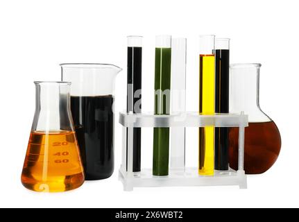 Becher, provette e matracci con diversi tipi di olio isolati su bianco Foto Stock