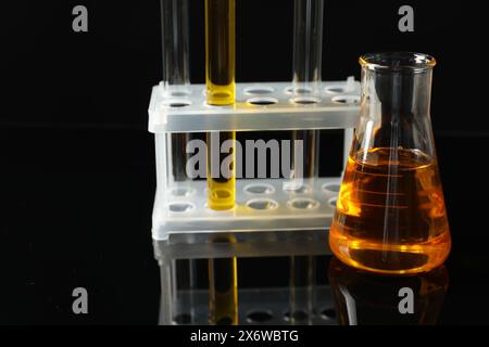 Vetreria da laboratorio con diversi tipi di olio su sfondo nero Foto Stock