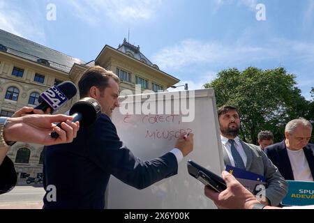 Bucarest, Romania. 16 maggio 2024: Sebastian Burduja, Ministro dell'energia e candidato del Partito Nazionale Liberale per il Sindaco di Bucarest, tiene una conferenza stampa di fronte al Municipio generale, sul finanziamento della campagna pre-campagna e della campagna dell'attuale sindaco Nicuşor Dan. Sulla lavagna c'è scritto "è vero, Nicusor?" Crediti: Lucian Alecu/Alamy Live News Foto Stock