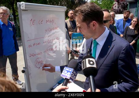 Bucarest, Romania. 16 maggio 2024: Sebastian Burduja, Ministro dell'energia e candidato del Partito Nazionale Liberale per il Sindaco di Bucarest, tiene una conferenza stampa di fronte al Municipio generale, sul finanziamento della campagna pre-campagna e della campagna dell'attuale sindaco Nicuşor Dan. Sulla lavagna c'è scritto: "Perché mente, Nicusor?" Crediti: Lucian Alecu/Alamy Live News Foto Stock