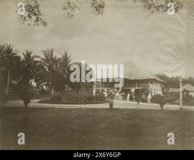 Casa di Paul e Lucie Sandel a Tandjong Poera, Haus Paul Sandel, Sumatra (titolo sull'oggetto), Paul Sandel posa davanti alla casa, insieme ad altri europei, servitori indonesiani e lavoratori cinesi a contratto., fotografia, Heinrich Ernst & Co., (menzionato sull'oggetto), Tandjong Poera, c. 1900 - c. 1905, carta, stampa albume, altezza, 271 mm x larghezza, 351 mm Foto Stock