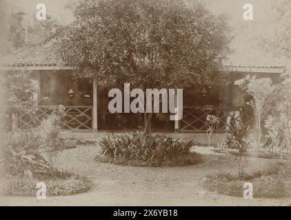 Giardino in una casa con veranda nelle Indie Orientali olandesi, parte dell'album di viaggio con foto di luoghi d'interesse in Italia, Svizzera e Indie Orientali olandesi., fotografia, anonimo, Indie Orientali olandesi, c. 1895 - c. 1905, carta, altezza, 120 mm x larghezza, 165 mm Foto Stock