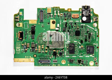 una delle schede a circuito stampato in un telefono cellulare in cui sono collegati i componenti Foto Stock