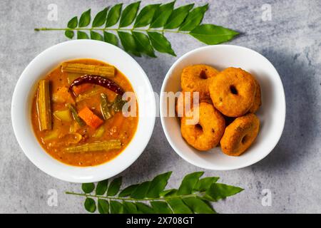 Focalizzazione selettiva del famoso cibo dell'India del Sud 'Medu vadaa' con sambar e chatney di cocco. Foto Stock