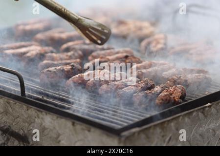 Profondità di campo ridotta (messa a fuoco selettiva) dettagli con macine di carne macinata alla griglia in forma cilindrica sulla barbe Foto Stock